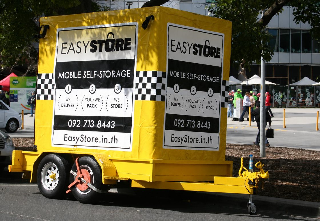 EasyStore self storage delivery trailer parked on a city street ready to drop off a storage box
